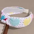Dettaglio della fascia bianca lavorata a mano a maglia con cuori colorati e texture crochet - Cuore Multicolore Annodato