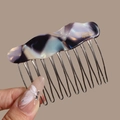 Detail of marble pattern acetate hair comb with gold teeth and handmade text engraving - Wavy Purple Black (Marble)