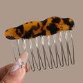 Close-up of tortoise shell acetate bow hair comb with silver metal teeth and engraving - Wavy Leopard