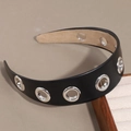 Serre-tête large en cuir PU avec œillets métalliques argentés sur un fond de studio - Noir