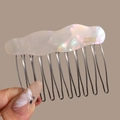 Detailed macro view of the iridescent acetate wave pattern on the metal French hair comb - Wavy White (Iridescent)