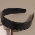 Detail van de zwarte kunstlederen haarband met grijze vlechtstiksels en vintage minimalistische stijl - Zwart