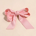 Detail der rosa Satin-Schleife Haarspange mit langen Bändern und glatter Textur - Rosa