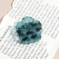 Detailed close-up of dark green flower hair claw clip with transparent resin finish - Blue Cherry Blossom