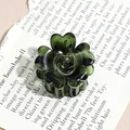 Detailed top view of a dark green translucent rose flower hair claw clip on art paper - Green Rosebud