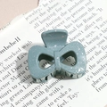 Macro shot of teal bow hair claw with silver sequins on vintage newspaper background - Bow / Blue Green (Splash Ink)