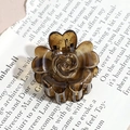 Detailed close-up of a vintage amber resin flower hair claw clip with heart-shaped petals - Brown Rosebud