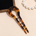 Close-up of a tortoiseshell acetate U-shaped hair pin with wavy double teeth on a tray - Dark Leopard Print