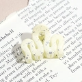 Close-up of wavy cream hair claw clip with silver glitter on vintage newspaper background - Wavy Line / Cream Yellow (Splash Ink)