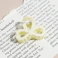 Macro detail of cream resin hair claw with silver splash pattern on vintage newspaper - Three-Petal Flower / Milk Yellow (Splash Ink)