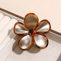 Macro-opname van vintage hars bloem haarklem met schildpadmotief en gouden inlays - Champagne