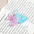 Détail d'une pince à cheveux papillon avec dégradé rose et bleu sur papier design - Papillon Évidé Bleu Rose