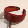Detailweergave van een bordeauxrode gevlochten lederen hoofdband met verfijnde stiksels - Glad Lederen Stijl / Effen Wijnrood