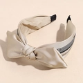 Close-up of champagne satin headband with bow knot, houndstooth edge, and pearl accents - Champagne Bowknot