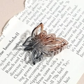 Pince à cheveux papillon évidée élégante avec dégradé de résine sur livre ancien - Papillon Évidé Gris Brun