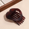 Detail of hollow heart-shaped hair claw in dark amber resin on beige textured background - Matte Dark Red Leopard