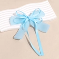 Detail of light blue bow hair clip featuring layered organza and smooth satin ribbon fabrics - Blue