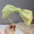Détail du serre-tête avec nœud en organza vert clair aux reflets nacrés élégants - Vert
