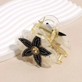 Dettaglio del fermaglio a fiore in rete con centro di strass e base in resina - Champagne