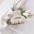 Macro detail of cream marble texture hair claw clip on beige canvas background - Creamy White Marble Style / Off White