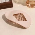 Dettaglio di un fermaglio per capelli ovale beige opaco con elegante intaglio a rombo - Beige
