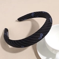 Detailed view of striped fabric headband texture with blue bow prints and hand made label - Black