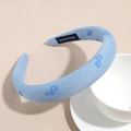 Detail eines hochwertigen Twill-Haarbands mit marineblauem Schleifenmuster und Handmade-Label - Hellblau