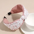 Detalle de diadema trenzada con estampado floral blanco y forro rosa suave - Rosa
