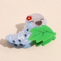 Close-up of a blue cartoon caterpillar hair claw clip with green leaf and flower detail - Light Blue Silkworm