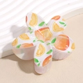 Detailansicht einer Blumen-Haarklammer mit lebendigen Orangenmotiven und grünen Blättern - Orange
