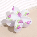 Detailansicht der weißen Blumen-Haarklammer mit lila Traubenmuster und glänzendem Finish - Trauben