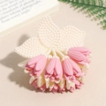 Close-up of matte pink tulip flower claw clip with cream leaves on a book - Pink