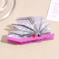 Primer plano de pinza de pelo creativa en forma de libro con acabado perlado y marcapáginas - Libros Rosa