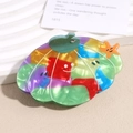 Detailed close-up of shell-shaped acetate hair claw with mosaic pattern and starfish detail - Colorful