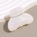 Détail macro d'une pince à cheveux élégante en acétate perlé avec strass étincelants - Blanc