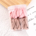 Close-up of pink and brown elastic hair ties stored in a clear lidded container - Pink Series