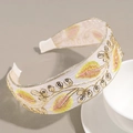 Dettaglio di ricamo a foglie e paillettes su una fascia per capelli larga in crema - Giallo