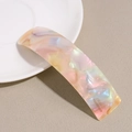 Detail showing the iridescent marble texture and engraved text on the acetate hair clip - Multi-color Marble