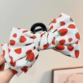 Chic hair claw clip with large red strawberry print bow on a white fabric base - Strawberry