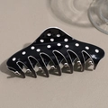 Vista macro della clip per capelli a pois bianchi e neri con finitura lucida - Nero