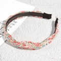 Detail showing non-slip plastic teeth and pink floral fabric of the knotted headband - Off White