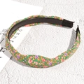 Detail of green floral knot headband with anti-slip teeth and soft fabric ends - Green