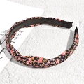 Close-up detail of floral fabric headband with top knot and anti-slip teeth - Black Floral Pink