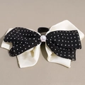 Detalle de una pinza para el pelo con lazo de satén, malla de lunares y perla de estilo retro - Estilo de Lunares en Blanco y Negro