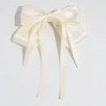Detailaufnahme der eleganten elfenbeinfarbenen Satin-Schleife mit langen Bändern für Haar - Beige