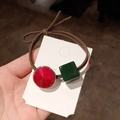 Macro shot of elastic hair tie with red gemstone and green square charm detail - Green Square