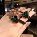 Close-up of elastic hair ties with emerald green and champagne crystal charms on wrist - Green Triangle