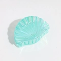 Detailopname van de schelpvormige haarklem met iriserende mintgroene glans en textuur - Meerblauw
