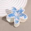 Detaillierte Draufsicht einer weißen Harz-Haarklammer mit blauem floralem Frangipani-Print - Blau