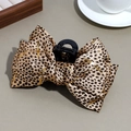 Detail of leopard print bow hair claw with gold foil accents on a minimalist background - Gold Thread Small Leopard